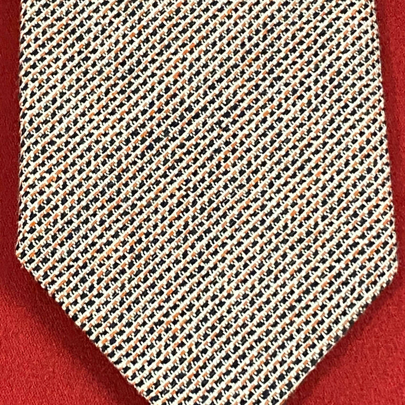 „Detailaufnahme Vintage Krawatte mit feinem geometrischem Muster in Beige und Braun“