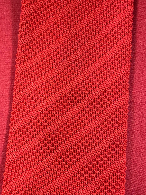 „Detailaufnahme rote Strickkrawatte mit feiner Struktur im Retro Stil“