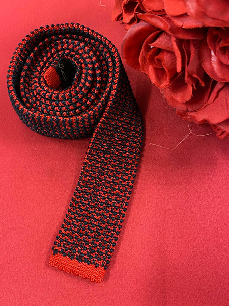 „Vintage Strickkrawatte rot schwarz aus Seide mit auffälligem Muster auf rotem Hintergrund“