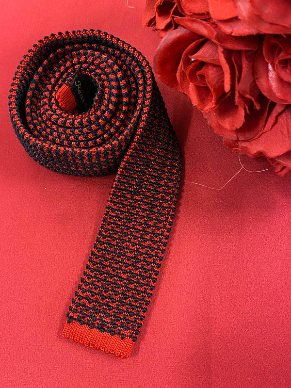 „Vintage Strickkrawatte rot schwarz aus Seide mit auffälligem Muster auf rotem Hintergrund“