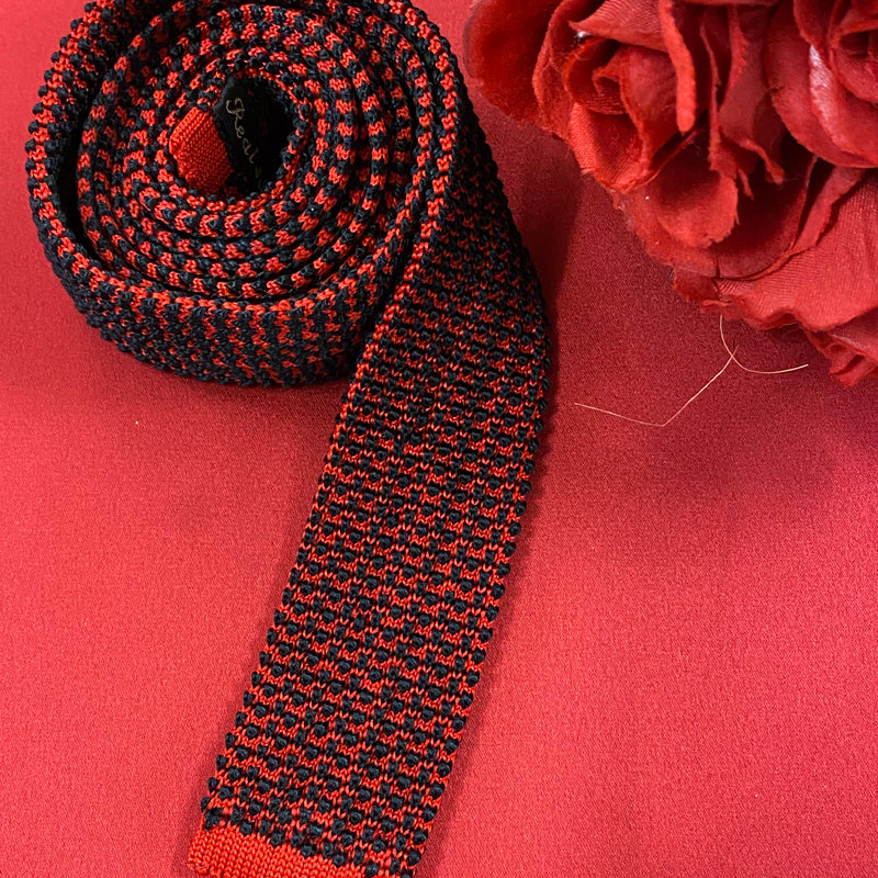 „Vintage Strickkrawatte rot schwarz aus Seide mit auffälligem Muster auf rotem Hintergrund“