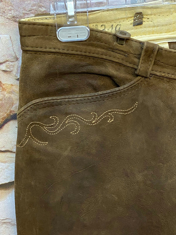 „Detailaufnahme dunkelbraune Vintage Lederhose von Beckert Moden mit heller Stickerei an der Tasche“