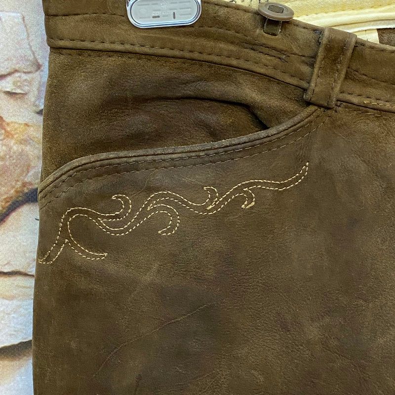 „Detailaufnahme dunkelbraune Vintage Lederhose von Beckert Moden mit heller Stickerei an der Tasche“