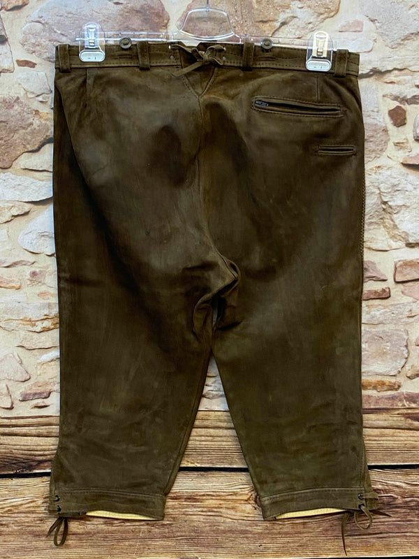 „Rückseite einer Vintage Lederhose dunkelbraun mit Gesäßtasche und schnürbaren Beinabschlüssen“