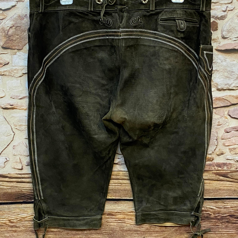 „Rückseite einer olivbraunen Stockerpoint Trachten Lederhose mit Ziernähten und Schnürung am Bund“