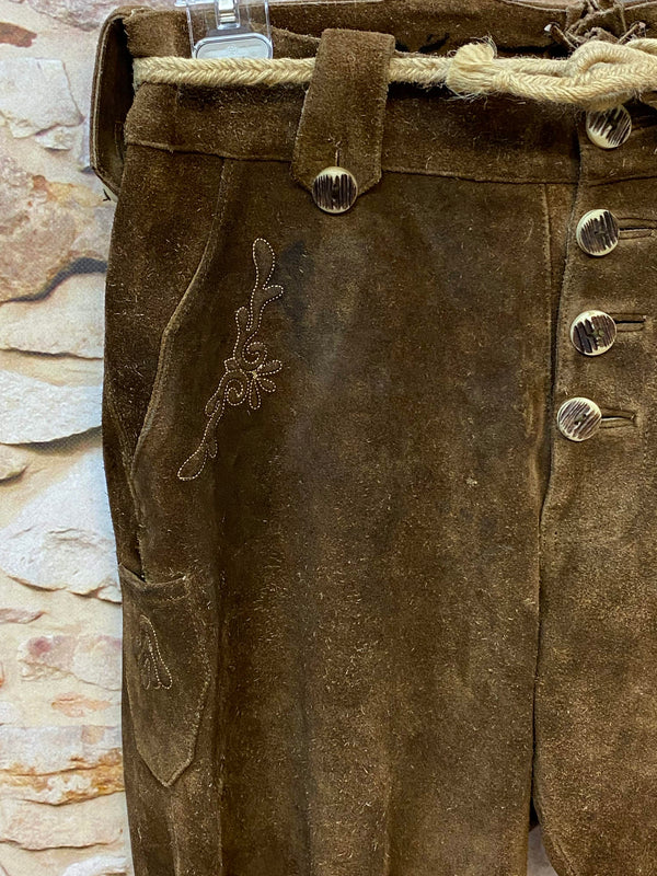 „Detailaufnahme dunkelbraune Trachtenlederhose aus Veloursleder mit Hornknöpfen und traditioneller Stickerei“