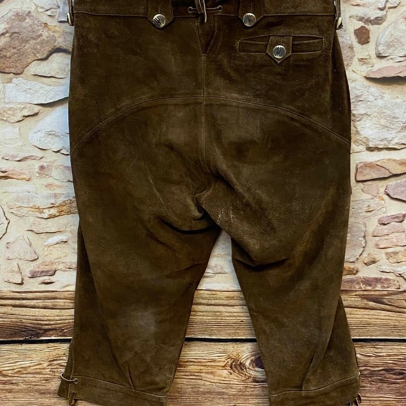 „Rückseite einer dunkelbraunen Trachten Lederhose Herren mit Gesäßtasche, Hornknöpfen und Schnürung“