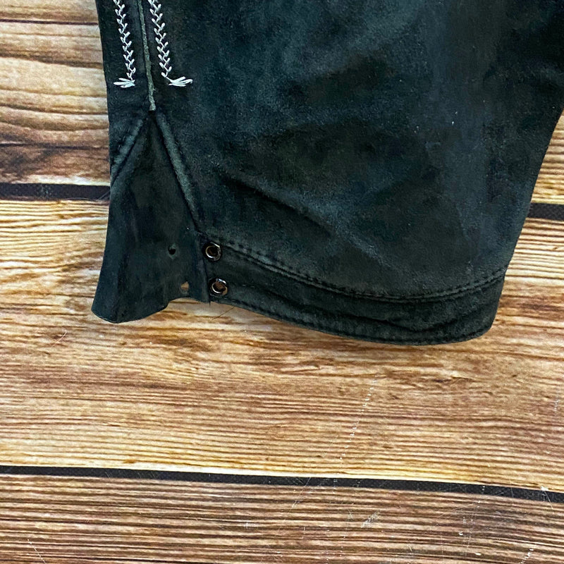 „Beinabschluss einer schwarzen Vintage Lederhose mit Knöpfen und dekorativer Trachtenstickerei“