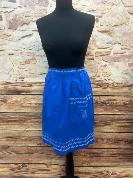 „Königsblaue Vintage-Trachtenschürze aus Baumwolle mit hellen Stickbordüren, 1970er, Frontansicht am Mannequin.“