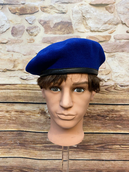 „Blaues Vintage Uniform-Barett Größe 59 aus 100 Prozent Wolle mit schwarzem Rand auf Schaufensterkopf“