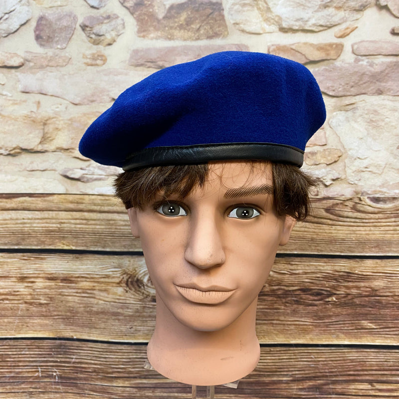 „Blaues Vintage Uniform-Barett Größe 59 aus 100 Prozent Wolle mit schwarzem Rand auf Schaufensterkopf“