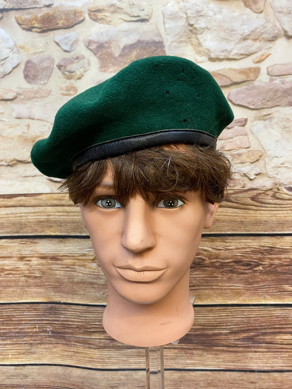 „Grünes Vintage Uniform-Barett Größe 59 mit schwarzem Rand auf Schaufensterkopf“
