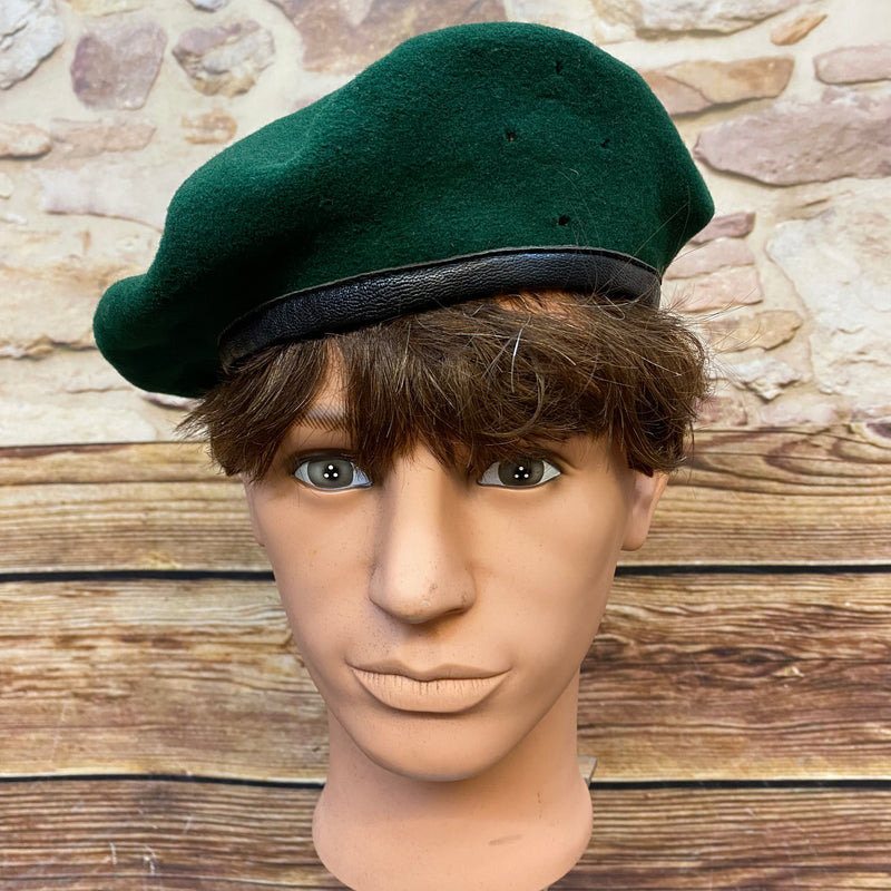 „Grünes Vintage Uniform-Barett Größe 59 mit schwarzem Rand auf Schaufensterkopf“