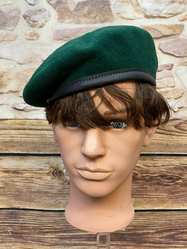 „Grünes Vintage Uniform-Barett Größe 60 aus 100 Prozent Wolle mit dunklem Rand auf Schaufensterkopf“