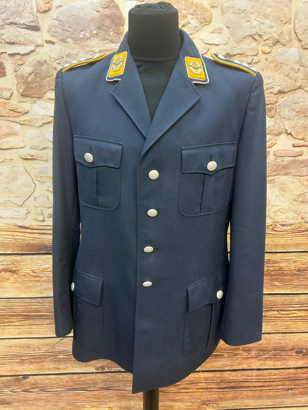 Dunkelblaue Vintage Uniformjacke für Herren in Größe 50 mit silbernen Knöpfen, Kragenspiegeln und Schulterklappen, frontal auf Schneiderpuppe vor Steinwand.
