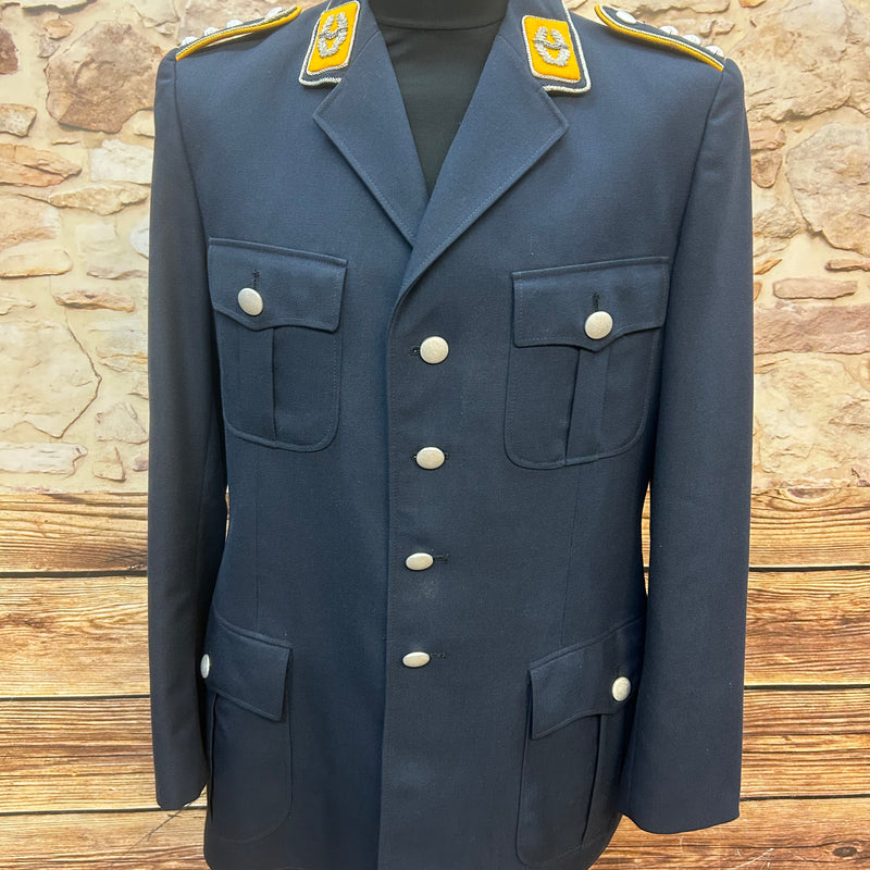 Dunkelblaue Vintage Uniformjacke für Herren in Größe 50 mit silbernen Knöpfen, Kragenspiegeln und Schulterklappen, frontal auf Schneiderpuppe vor Steinwand.