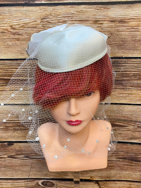 Eleganter Vintage Brauthut mit Schleife und Netzschleier, helles Creme