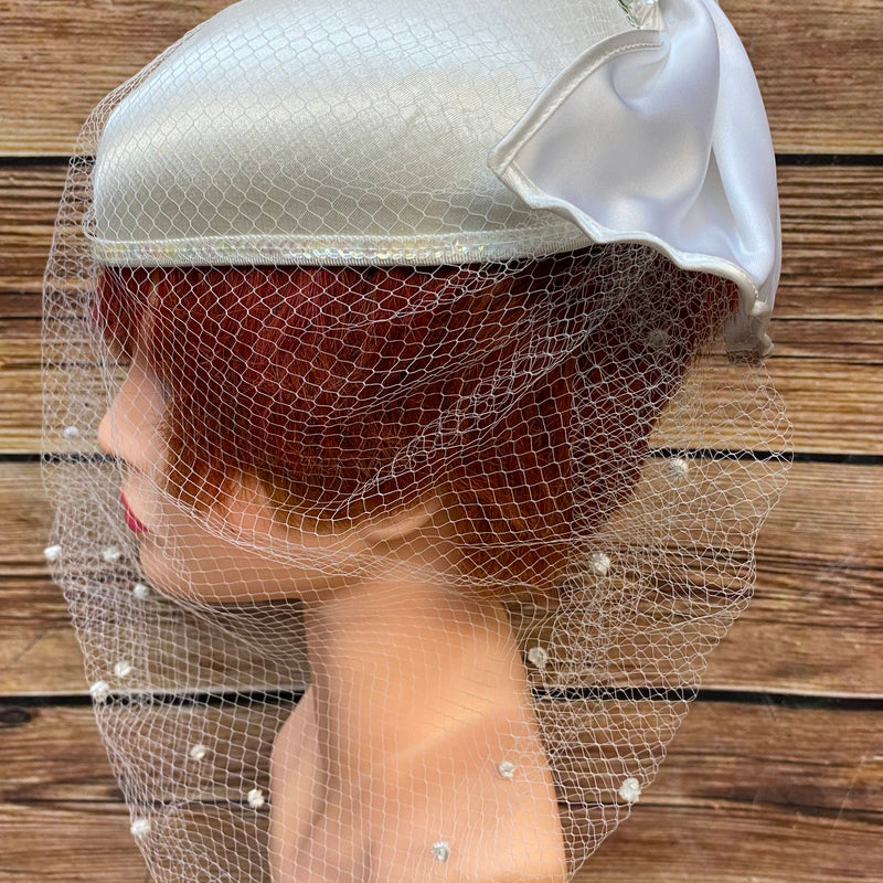 Eleganter Vintage Brauthut mit Schleife und Netzschleier, helles Creme