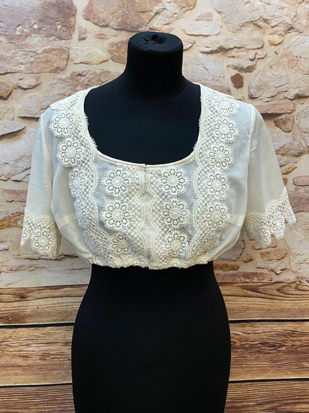 „Vintage Dirndlbluse aus den 80er-Jahren in Creme mit floraler Spitze am Ausschnitt und an den Ärmeln, halblang, elastischer Saum – Größe 42“