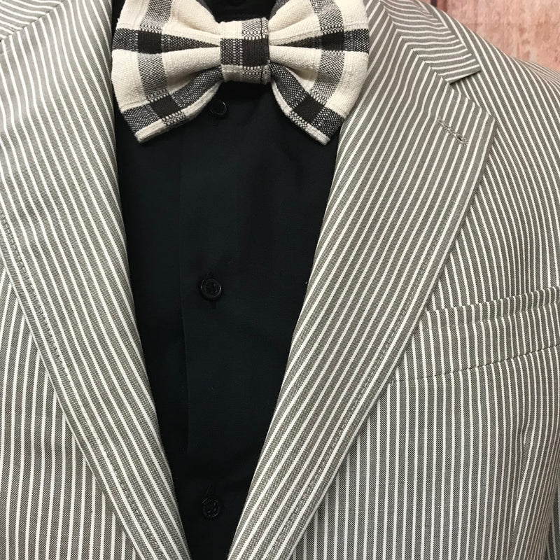 „Detailansicht Revers und Fliege – fein gestreifte 20er Jahre Herrenjacke in Beige-Grau mit schwarzem Hemd“