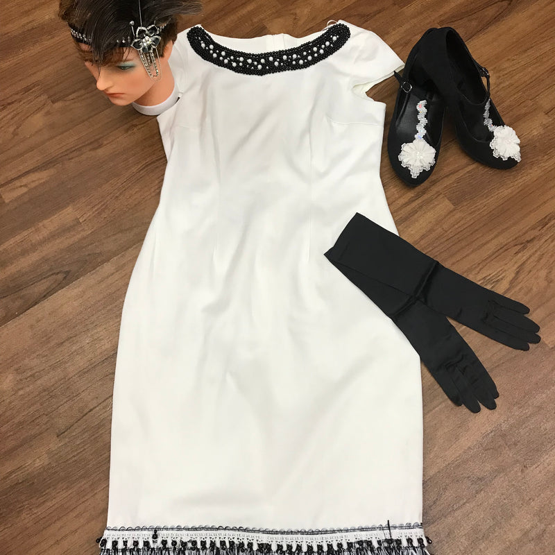 Cremeweißen Fransenkleid im 20er-Jahre-Stil, mit schwarzem Kopfschmuck, langen schwarzen Handschuhen, stilvollen T-Strap-Shoes in Größe 40