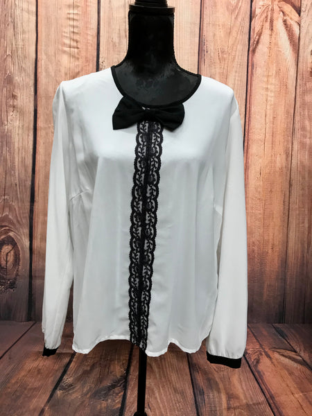Vorderansicht der Rainbow-Bluse in Creme, Größe 46, mit schwarzer Spitze und Schleife.