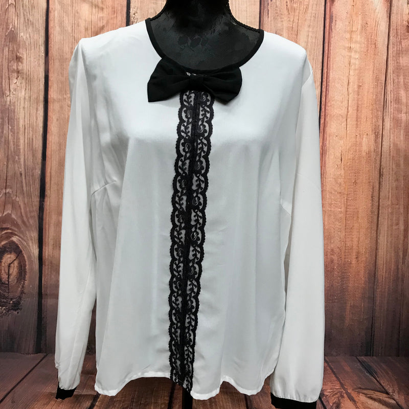Vorderansicht der Rainbow-Bluse in Creme, Größe 46, mit schwarzer Spitze und Schleife.