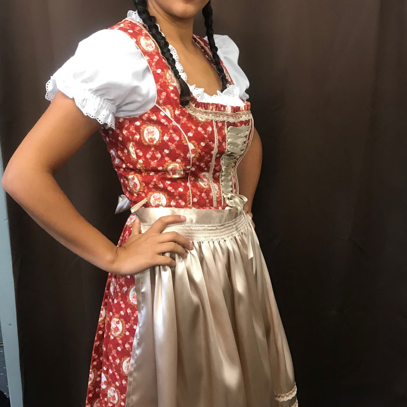 Model trägt rotes geblümtes Dirndl in Größe 40 mit beiger Schürze, seitliche Ansicht (Bluse im Foto, nicht im Lieferumfang)
