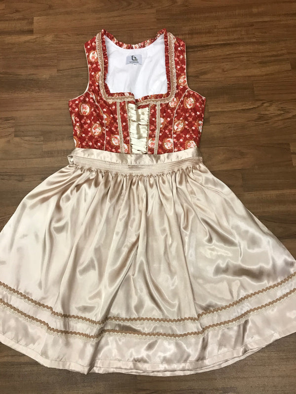 Dirndl flach gelegt mit gebundener beiger Schürze, Vorderansicht.