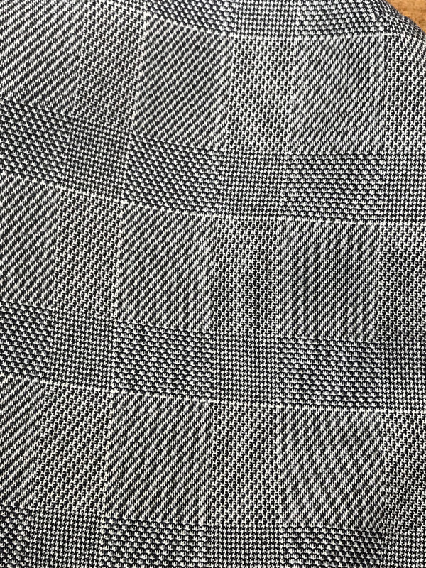 Detailaufnahme des karierten Stoffmusters in Grau.
