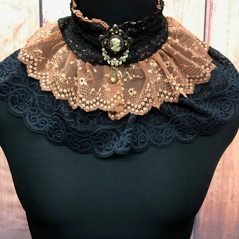 Steampunk Jabot aus schwarzer und kupferfarbener Spitze mit Cameo-Brosche, getragen auf Schneiderpuppe.