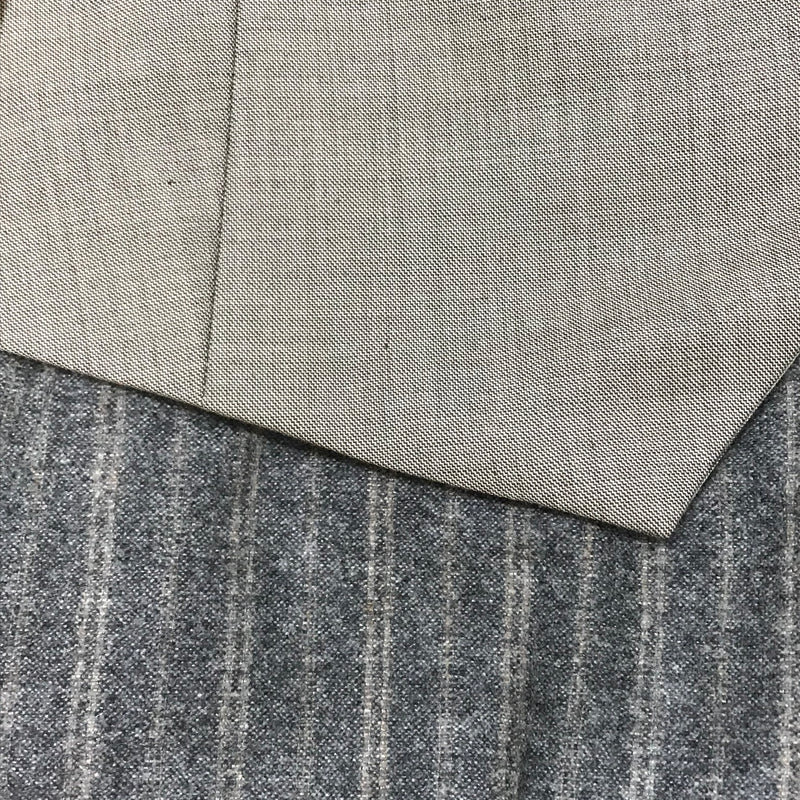 Graue Weste über Nadelstreifenhose – Stoff- und Kanten-Detail im 1920er-Stil