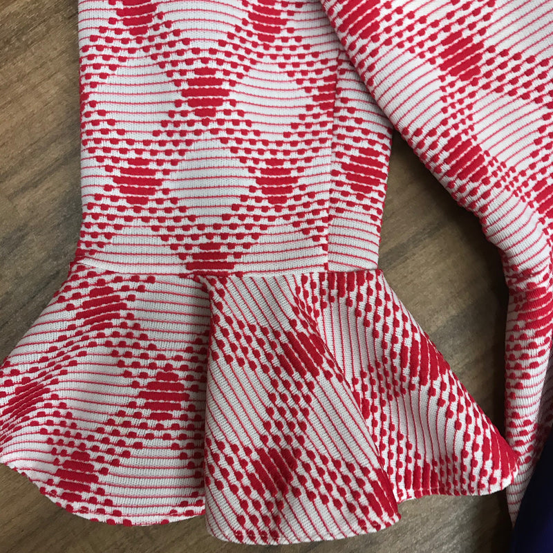 Detailaufnahme Ärmel mit rotem Volantmuster.