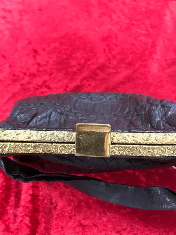 Goldfarbener, verzierter Rahmen der Vintage Lederhandtasche mit Verschluss.