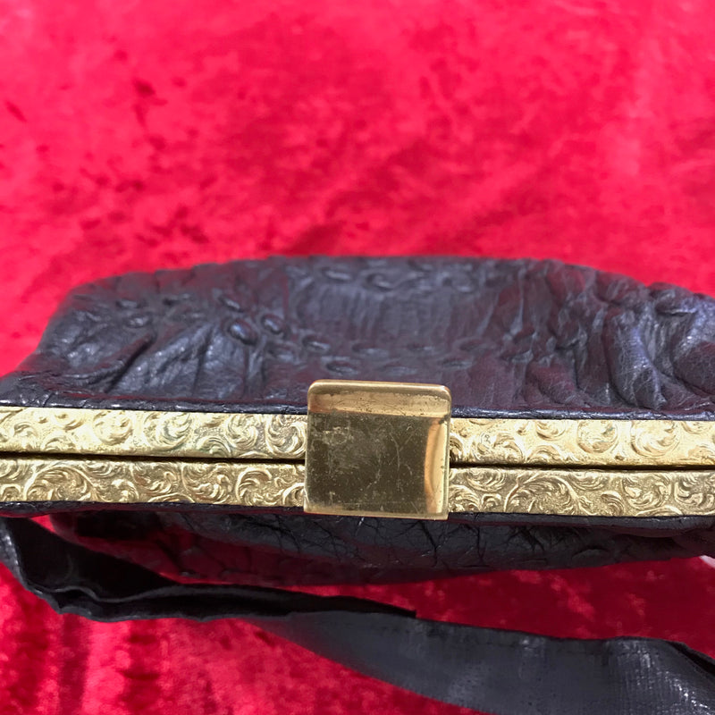 Goldfarbener, verzierter Rahmen der Vintage Lederhandtasche mit Verschluss.