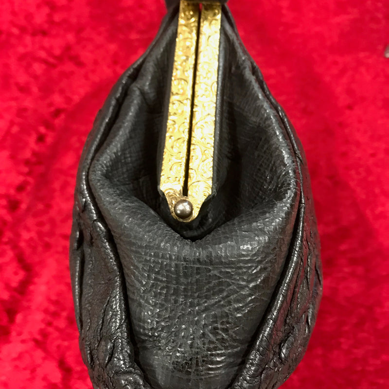 Seitenansicht der schwarzen Vintage Handtasche mit geprägtem Leder.