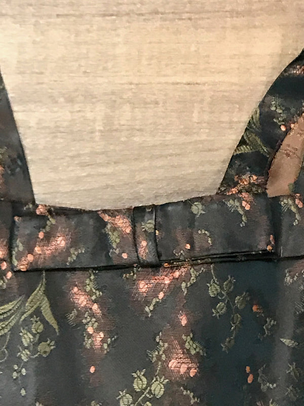 Detailaufnahme des Ausschnitts mit Brokatstoff und Schleifendetail