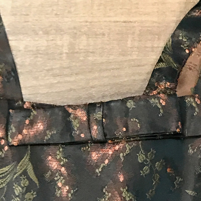 Detailaufnahme des Ausschnitts mit Brokatstoff und Schleifendetail