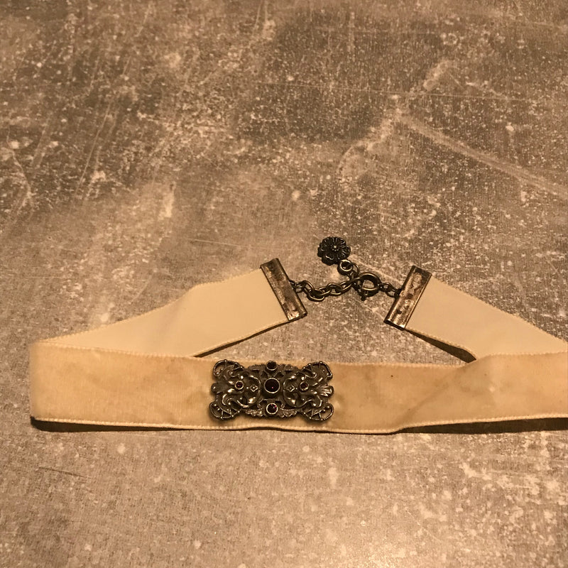 Vintage Kropfband aus hellem Samt mit silberfarbener Ornamentbrosche und roten Schmucksteinen.