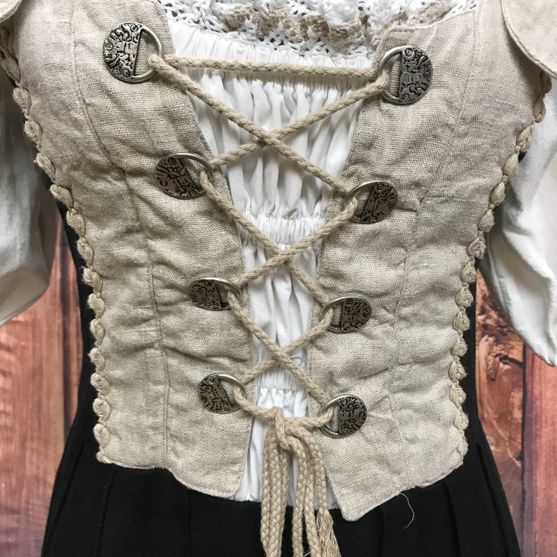 Detailaufnahme der Mieder-Schnürung mit altsilbernen Knöpfen am Oberteil.