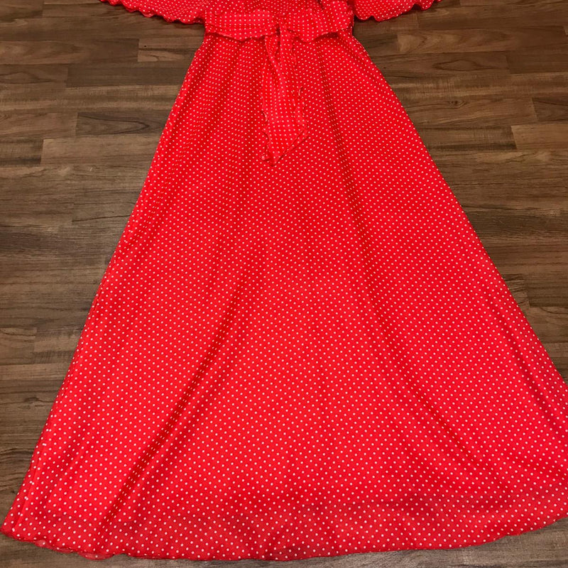 Kleid flach liegend: weite Cape-Ärmel, Bindegürtel und langer, schwingender Rock.
