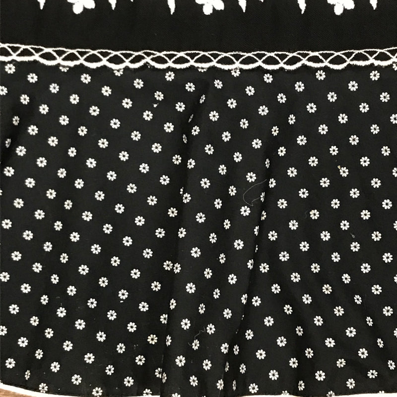 Detail der floralen Bordüre und des Volant-Saums am 70er-Vintage-Rock in Schwarz-Weiß