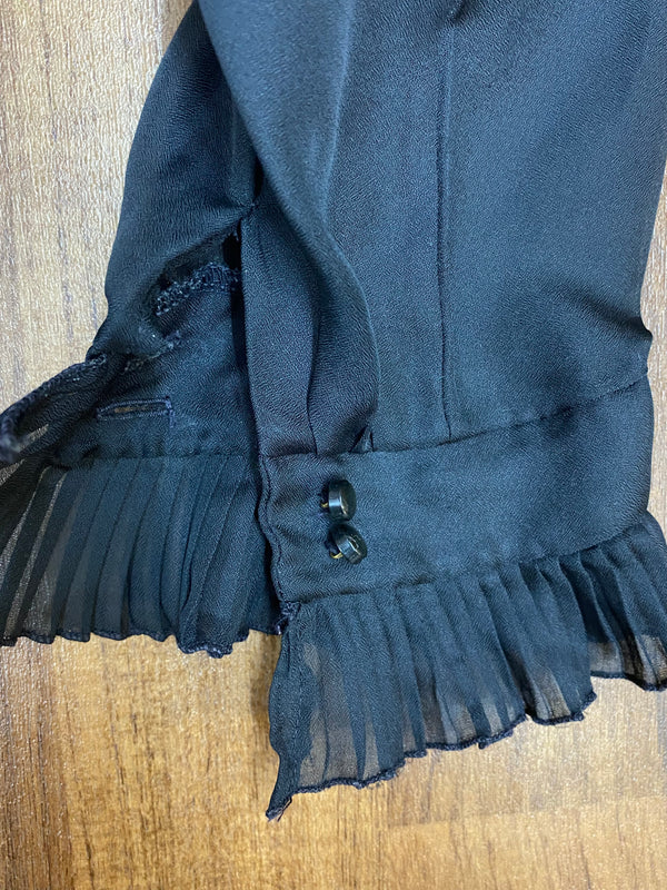 Detailaufnahme Manschette mit Rüschen und Doppelknopf der schwarzen Vintage-Bluse