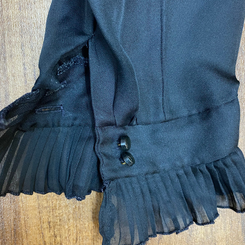 Detailaufnahme Manschette mit Rüschen und Doppelknopf der schwarzen Vintage-Bluse