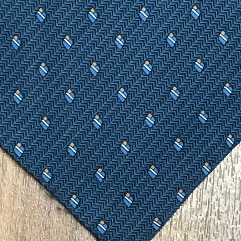 Detailaufnahme des geometrischen Musters in Hellblau und Gelb auf blauem Stoff