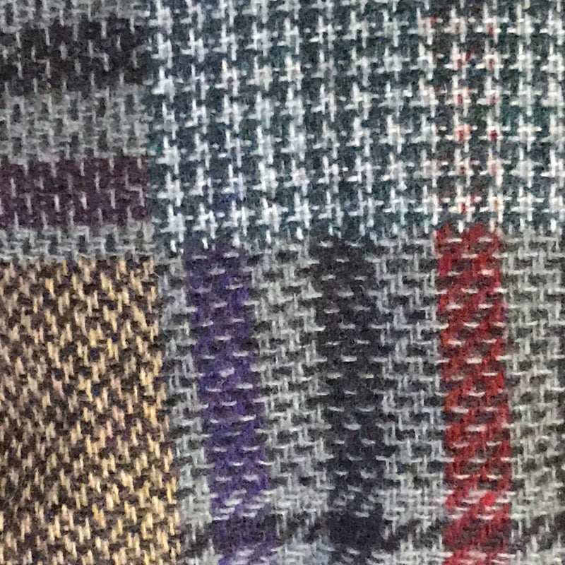 Detailaufnahme kariertes Patchwork-Muster der Vintage Schiebermütze, Wollmischung in Blau, Grau, Rot und Beige.
