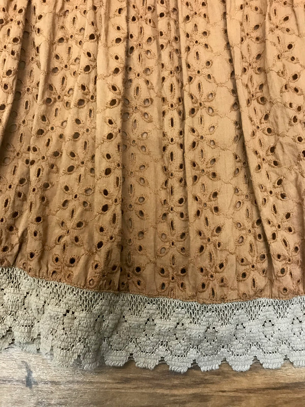 Detailaufnahme Broderie-Anglaise und beigefarbene Häkelspitze am Saum des Stufenrocks