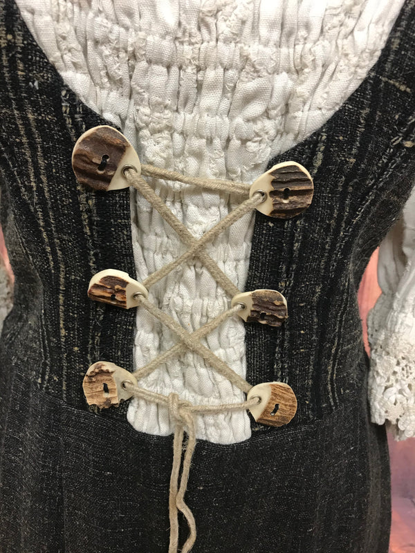 Detailaufnahme der Hornknöpfe mit Schnürung am Mieder des Trachtenkleids.
